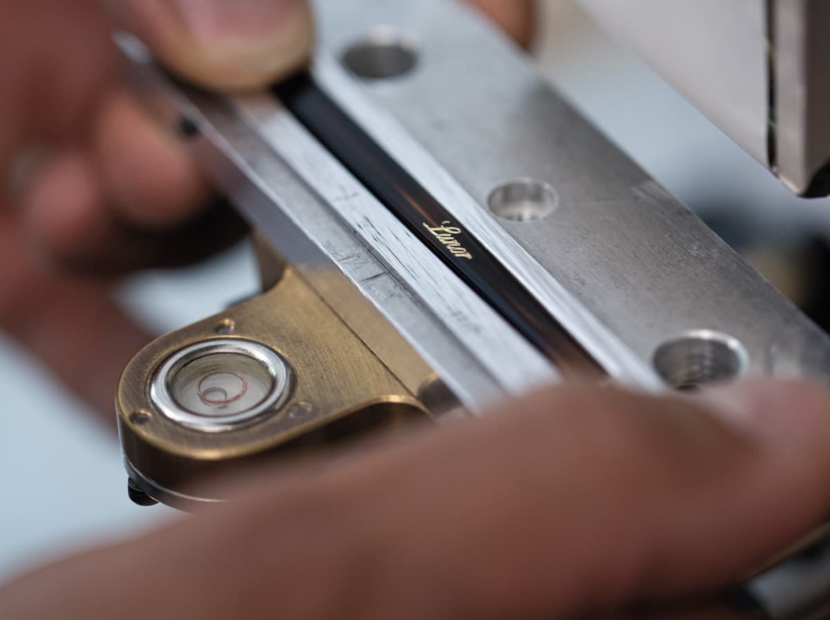 Ein Brillenbügel wird mit dem Lunor Logo versehen
